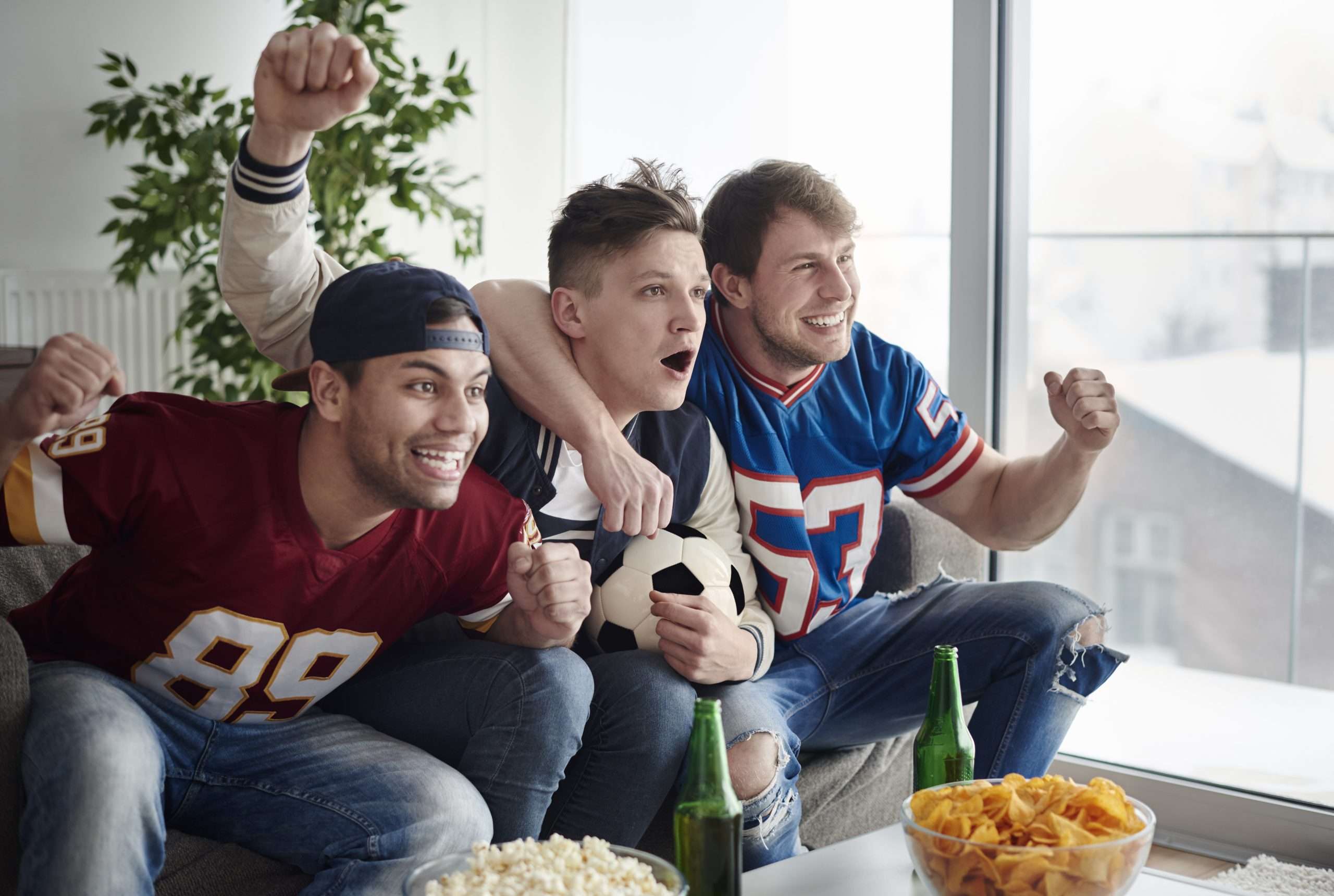 friends celebrating watching football on tv