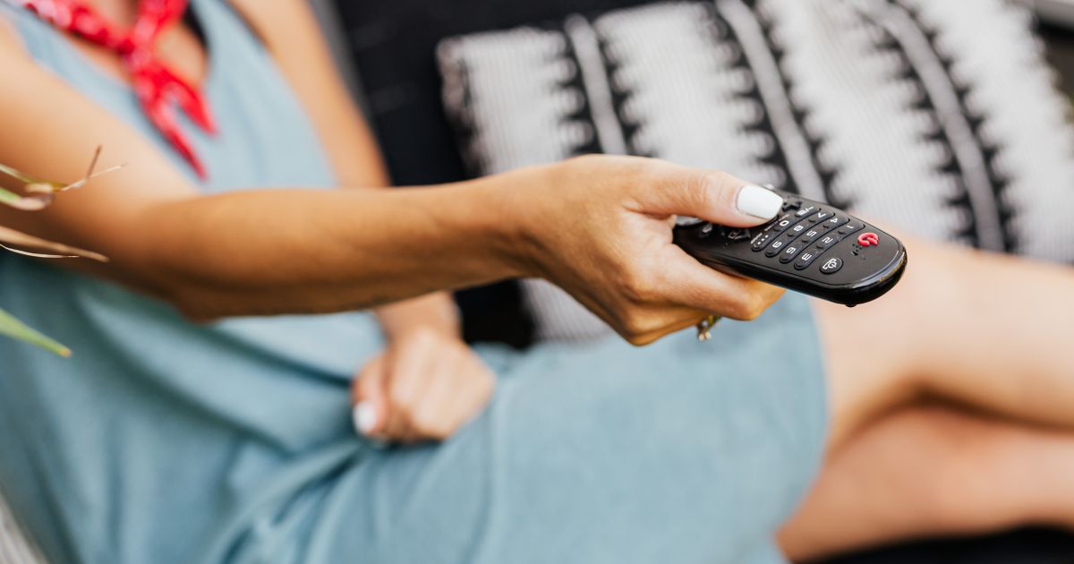 Streaming fatigue - a hand holding a TV remote - BoomTV